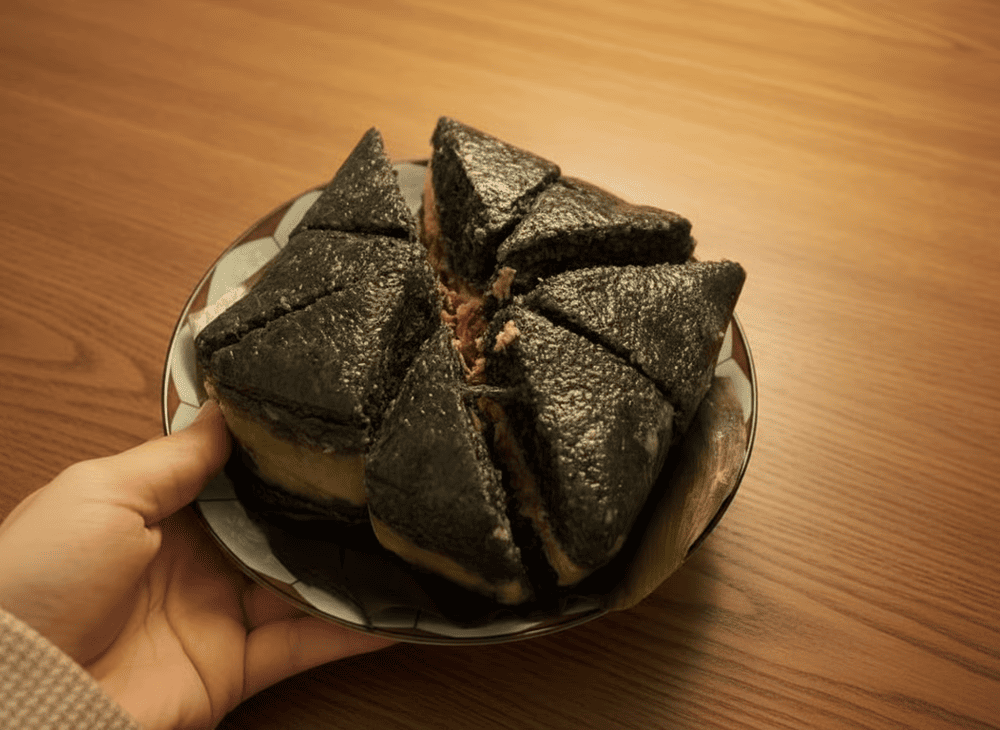 Bánh chưng đặc biệt với lá dong xanh, nhân đậu xanh và thịt heo, vỏ bánh có màu đen từ gạo nếp cẩm, ăn rất thơm và bổ dưỡng